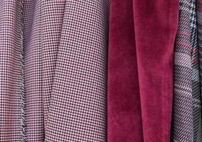 Detailed close up view on samples of cloth and fabrics in different colors found at a fabrics market photo