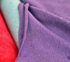 Detailed close up view on samples of cloth and fabrics in different colors found at a fabrics market photo