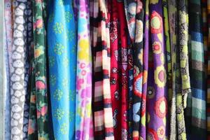 Detailed close up view on samples of cloth and fabrics in different colors found at a fabrics market photo