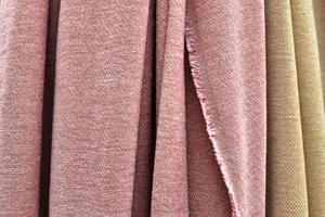 Detailed close up view on samples of cloth and fabrics in different colors found at a fabrics market photo