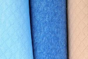Detailed close up view on samples of cloth and fabrics in different colors found at a fabrics market photo