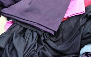 Detailed close up view on samples of cloth and fabrics in different colors found at a fabrics market photo