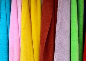 Detailed close up view on samples of cloth and fabrics in different colors found at a fabrics market photo