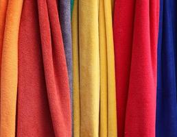 Detailed close up view on samples of cloth and fabrics in different colors found at a fabrics market photo