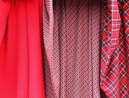 Detailed close up view on samples of cloth and fabrics in different colors found at a fabrics market photo