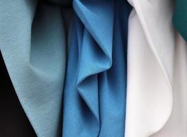 Detailed close up view on samples of cloth and fabrics in different colors found at a fabrics market photo