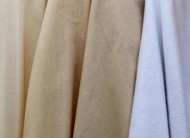 Detailed close up view on samples of cloth and fabrics in different colors found at a fabrics market photo