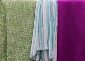 Detailed close up view on samples of cloth and fabrics in different colors found at a fabrics market photo