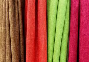 Detailed close up view on samples of cloth and fabrics in different colors found at a fabrics market photo