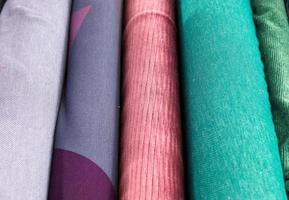 Detailed close up view on samples of cloth and fabrics in different colors found at a fabrics market photo