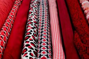 Detailed close up view on samples of cloth and fabrics in different colors found at a fabrics market photo