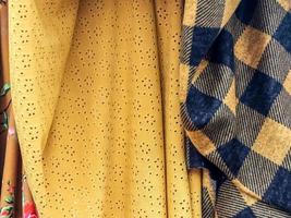 Detailed close up view on samples of cloth and fabrics in different colors found at a fabrics market photo