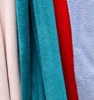 Detailed close up view on samples of cloth and fabrics in different colors found at a fabrics market photo