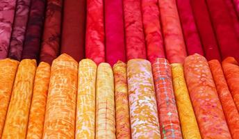 Detailed close up view on samples of cloth and fabrics in different colors found at a fabrics market photo