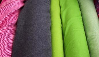 Detailed close up view on samples of cloth and fabrics in different colors found at a fabrics market photo