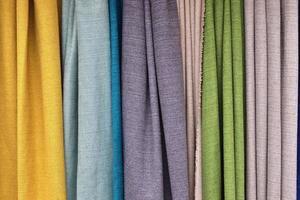 Detailed close up view on samples of cloth and fabrics in different colors found at a fabrics market photo