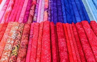 Detailed close up view on samples of cloth and fabrics in different colors found at a fabrics market photo