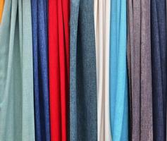 Detailed close up view on samples of cloth and fabrics in different colors found at a fabrics market photo