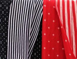 Detailed close up view on samples of cloth and fabrics in different colors found at a fabrics market photo