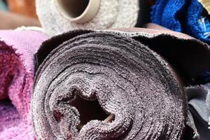 Detailed close up view on samples of cloth and fabrics in different colors found at a fabrics market photo