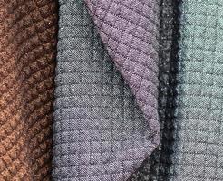 Detailed close up view on samples of cloth and fabrics in different colors found at a fabrics market photo