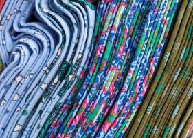 Detailed close up view on samples of cloth and fabrics in different colors found at a fabrics market photo