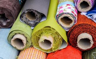 vista detallada de las muestras de telas y tejidos de diferentes colores que se encuentran en un mercado de tejidos foto