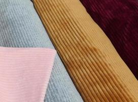 Detailed close up view on samples of cloth and fabrics in different colors found at a fabrics market photo