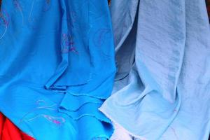Detailed close up view on samples of cloth and fabrics in different colors found at a fabrics market photo