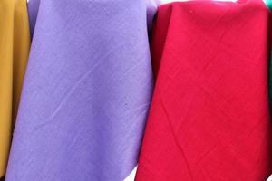 Detailed close up view on samples of cloth and fabrics in different colors found at a fabrics market photo