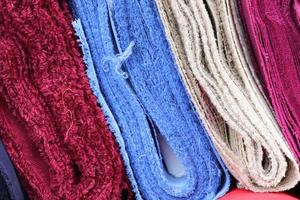 Detailed close up view on samples of cloth and fabrics in different colors found at a fabrics market photo