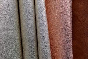 Detailed close up view on samples of cloth and fabrics in different colors found at a fabrics market photo