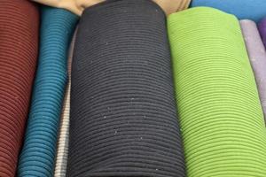 Detailed close up view on samples of cloth and fabrics in different colors found at a fabrics market photo