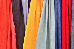 Detailed close up view on samples of cloth and fabrics in different colors found at a fabrics market photo