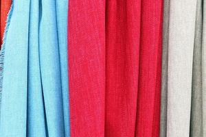 Detailed close up view on samples of cloth and fabrics in different colors found at a fabrics market photo
