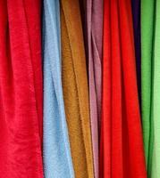 Detailed close up view on samples of cloth and fabrics in different colors found at a fabrics market photo