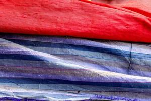 Detailed close up view on samples of cloth and fabrics in different colors found at a fabrics market photo