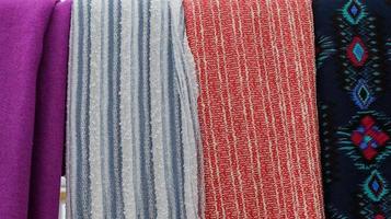 Detailed close up view on samples of cloth and fabrics in different colors found at a fabrics market photo
