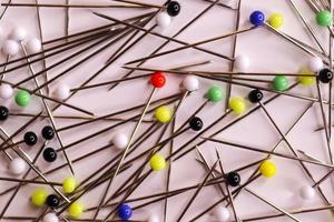 Selective focus of many pins with coloured glass heads on a white background. photo