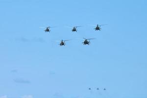 Military helicopters flying in blue sky performing demonstration flight, aerobatic team, air show photo