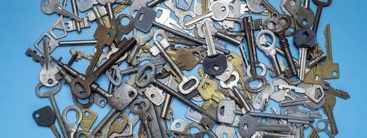 Keys set on blue background. Door lock keys and safes for property security and house protection. Different antique and new types of keys. photo