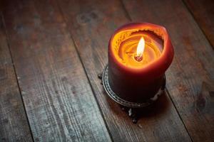 Big candle on wooden table photo