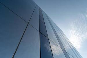 Modern mirror wall decoration of business center, copy space. Bottom view to texture of exterior design. Contemporary pattern of buildings. Looking up. photo