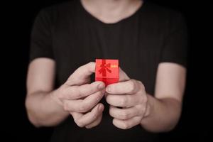 caja de regalo roja en mano en st. día de San Valentín foto