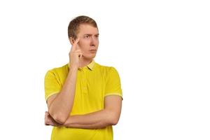 Thoughtful man in yellow T-shirt looking to right, white background, philosophical reflection photo