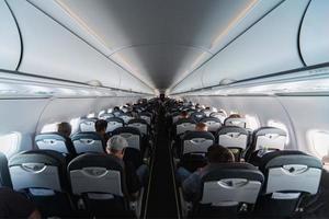 Airplane cabin seats with passengers. Economy class of new cheapest low-cost airlines without delay or cancellation of flight. Travel trip to another country. photo