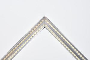 Strip LED lamp lighting with square aluminum profile on suspended ceiling in house, fragment, close photo