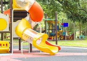 cierre el control deslizante colorido al aire libre y el equipo de juego en el patio de recreo en el parque público foto