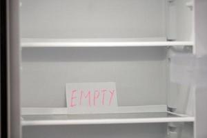 Empty refrigerator concept. Empty shelves of new refrigerator. Weight loss diet concept. photo