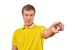 Nice handsome guy in casual yellow Polo T-shirt pointing forward isolated on white background photo